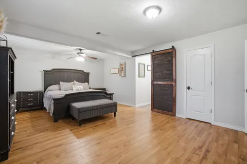 a bedroom with a bed and wooden floor