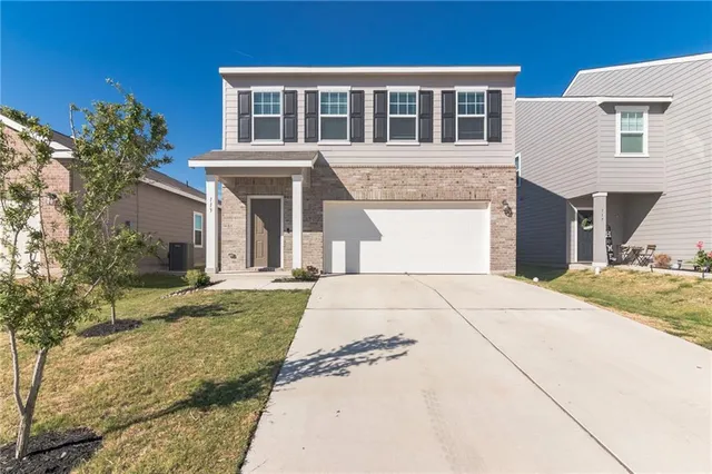 a front view of a house with a garden and patio