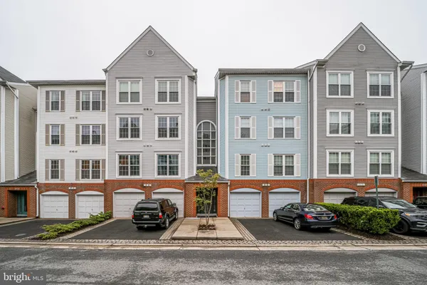 a front view of a building with lot of cars and trees