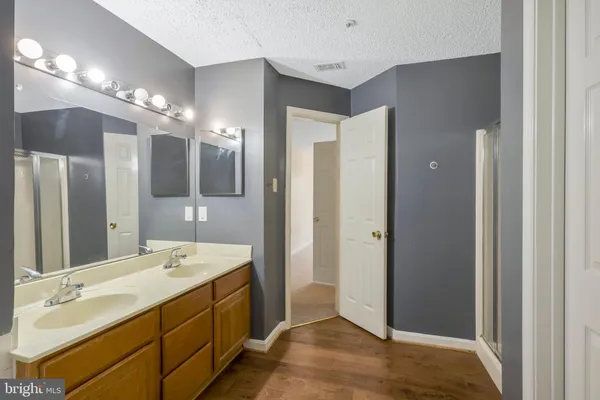a spacious bathroom with a double vanity sink mirror and shower