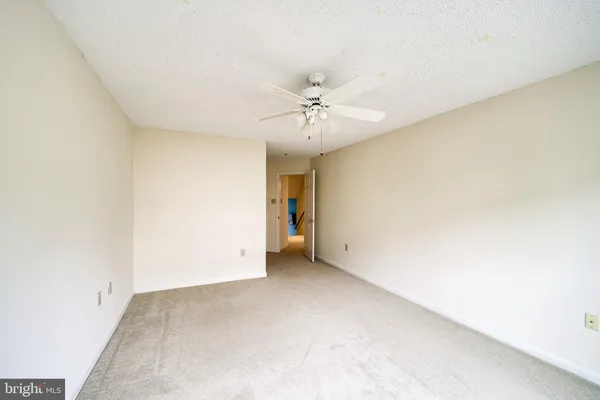 an empty room with a ceiling fan and a window