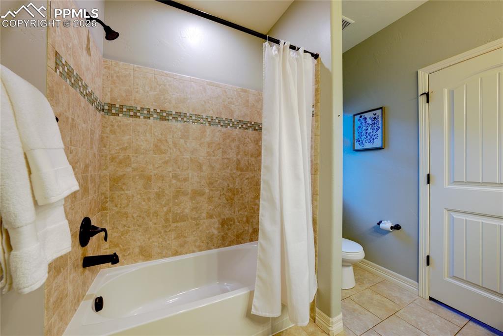 1112 Spectrum Loop Colorado Springs, CO 80921 - Photo 19 of 50 Bathroom featuring shower / bath combination with curtain and light tile patterned floors