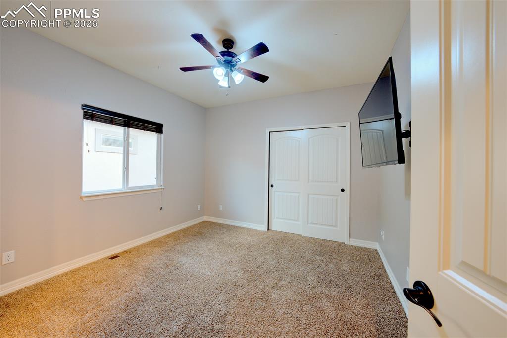 1112 Spectrum Loop Colorado Springs, CO 80921 - Photo 20 of 50 Unfurnished bedroom featuring carpet flooring, ceiling fan, and a closet