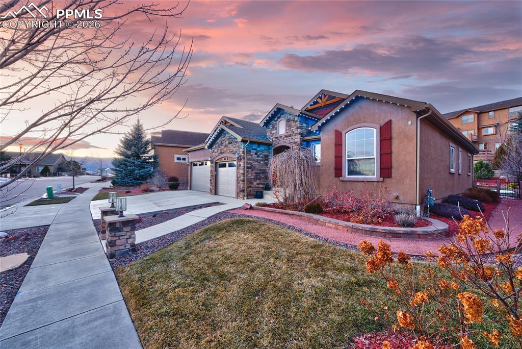 1112 Spectrum Loop Colorado Springs, CO 80921 - Photo 2 of 50 View of front of property with stucco siding, driveway, a front lawn, and a garage