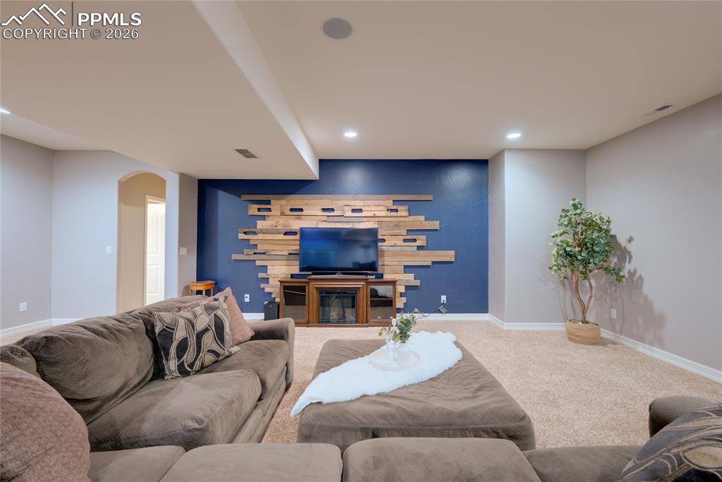 1112 Spectrum Loop Colorado Springs, CO 80921 - Photo 24 of 50 Carpeted living room featuring arched walkways and recessed lighting