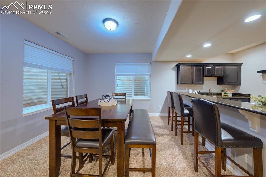 1112 Spectrum Loop Colorado Springs, CO 80921 - Photo 26 of 50 Dining room with light colored carpet and wet bar