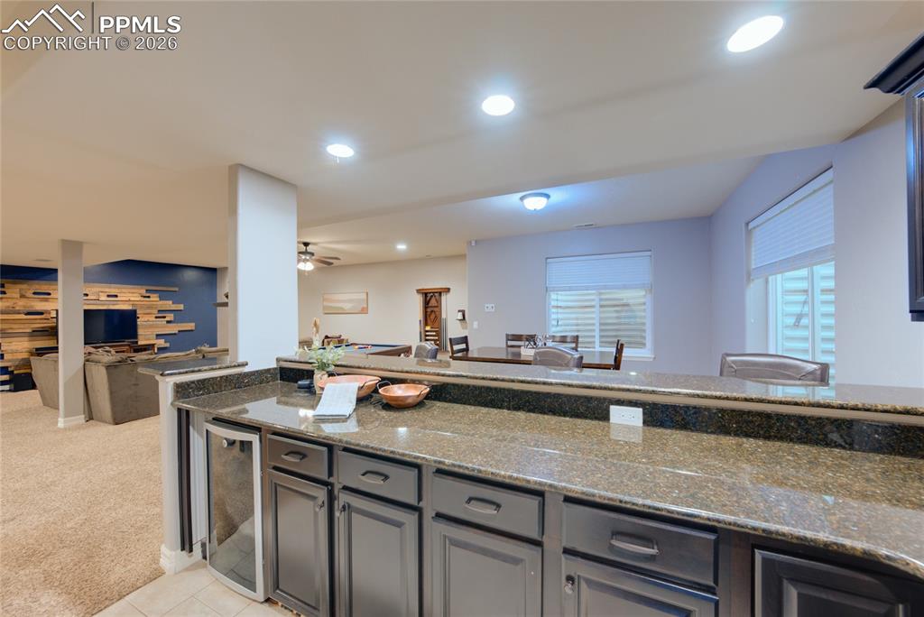 1112 Spectrum Loop Colorado Springs, CO 80921 - Photo 29 of 50 Kitchen with open floor plan, dark stone countertops, beverage cooler, recessed lighting, and light carpet