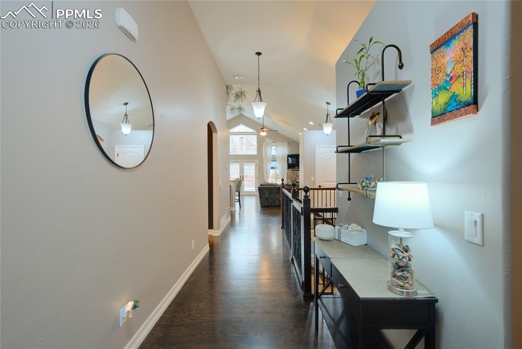 1112 Spectrum Loop Colorado Springs, CO 80921 - Photo 3 of 50 Hallway with lofted ceiling, an upstairs landing, and dark wood-style floors