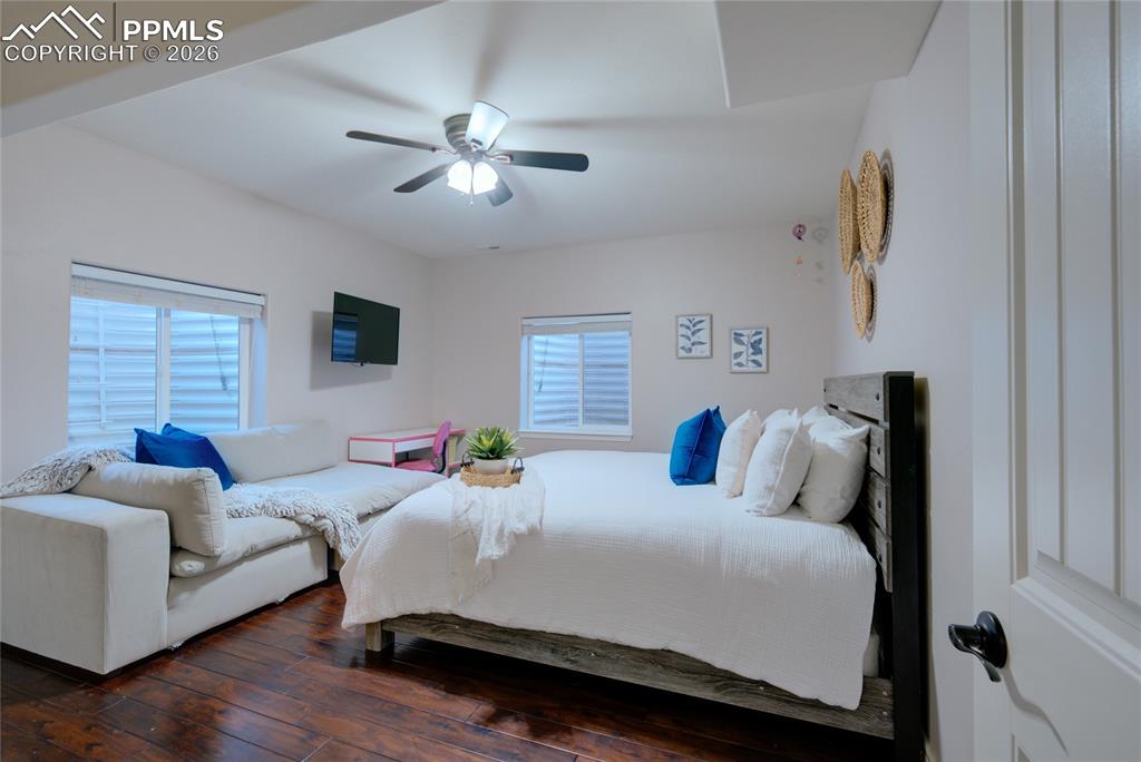 1112 Spectrum Loop Colorado Springs, CO 80921 - Photo 31 of 50 Bedroom with dark wood-style flooring, a ceiling fan, and multiple windows