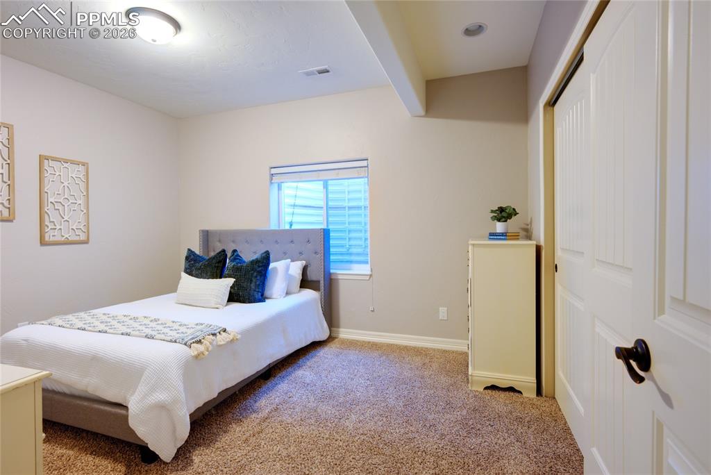 1112 Spectrum Loop Colorado Springs, CO 80921 - Photo 35 of 50 Bedroom with carpet, beam ceiling, and a closet