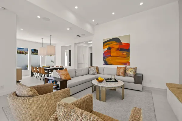 a large kitchen with a table chairs and a living room view