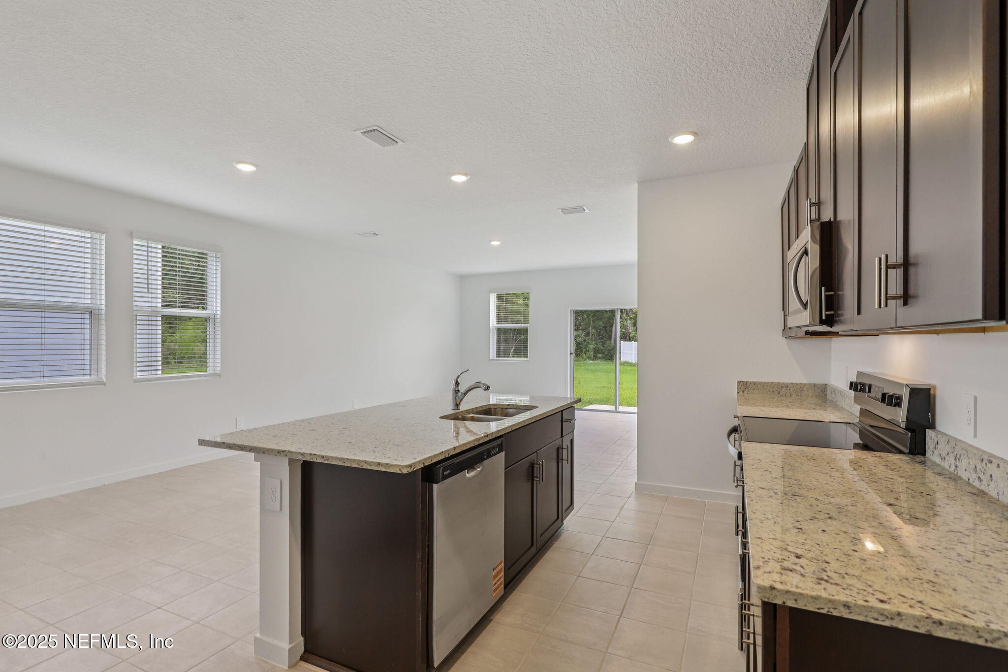 7351 Queensgate Circle Jacksonville, FL 32219 - Photo 14 of 38 a kitchen with granite countertop stainless steel appliances a sink stove and cabinets