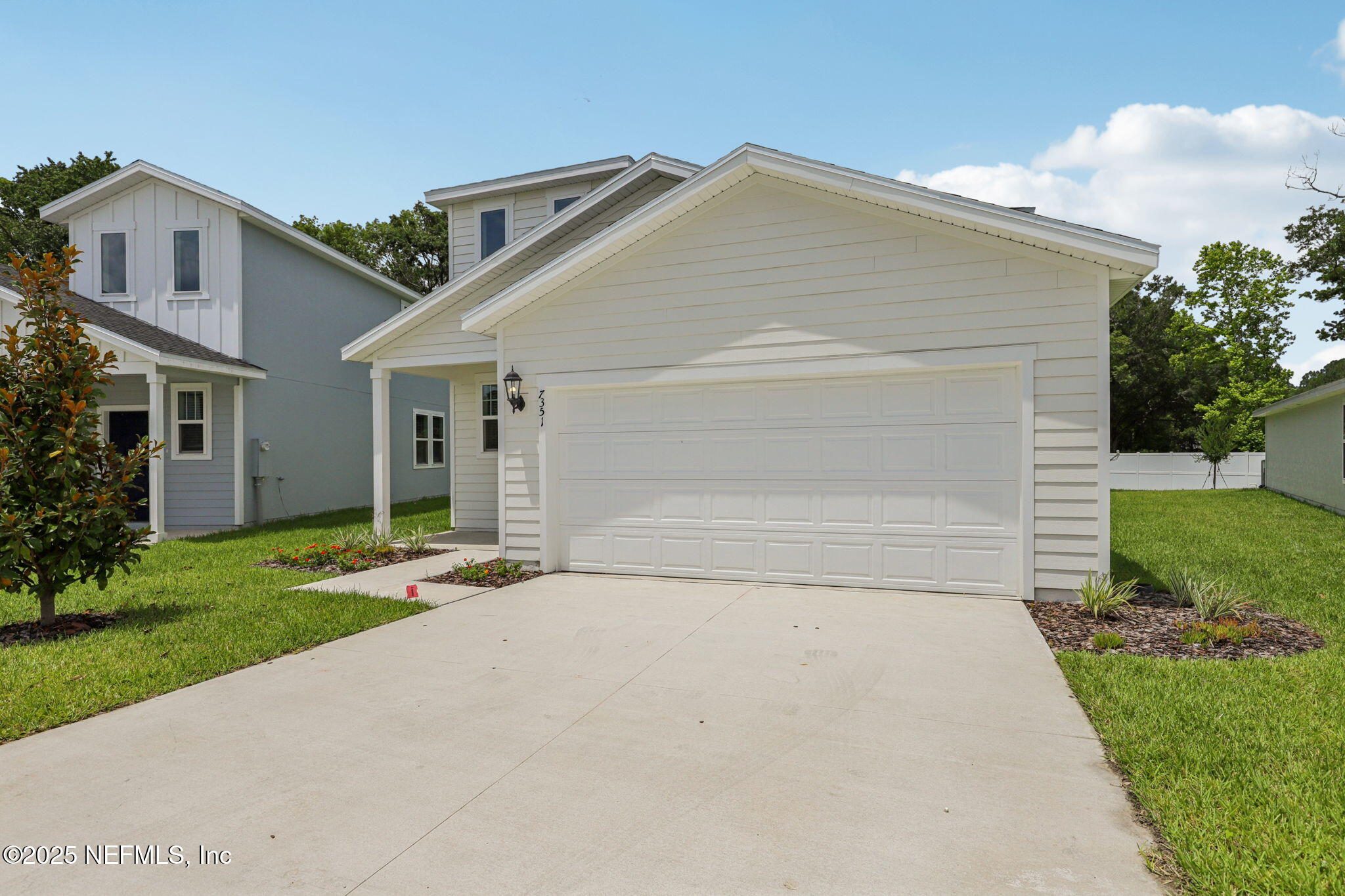 7351 Queensgate Circle Jacksonville, FL 32219 - Photo 2 of 38 a front view of a house with a yard and garage