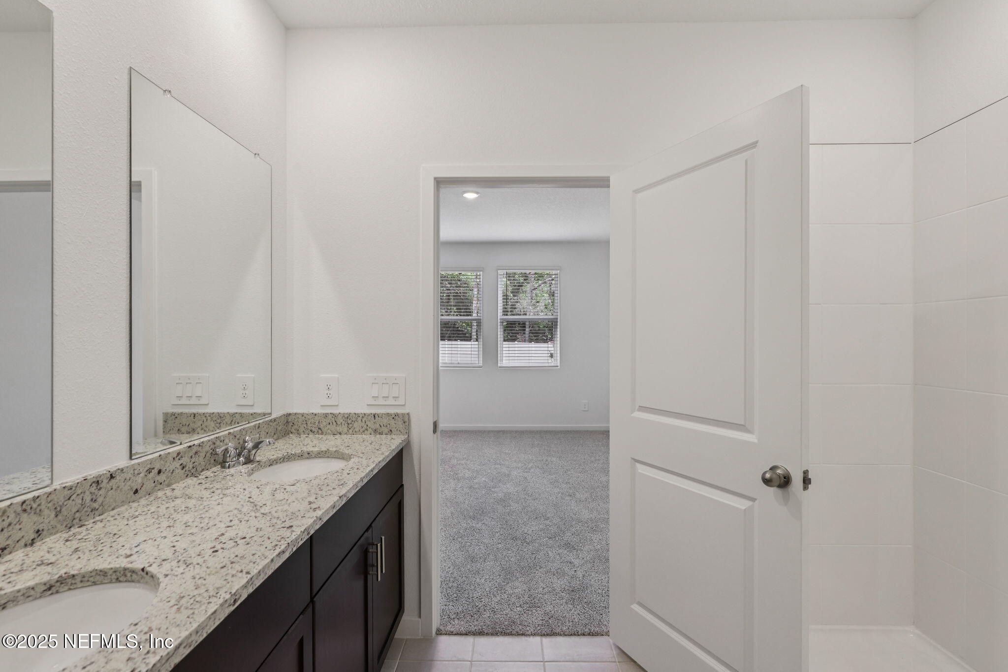 7351 Queensgate Circle Jacksonville, FL 32219 - Photo 23 of 38 a bathroom with a granite countertop sink and a mirror