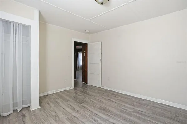 a view of an empty room with wooden floor