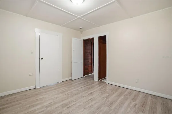 a view of an empty room with wooden floor