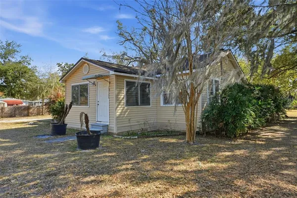a view of a house with backyard and trees