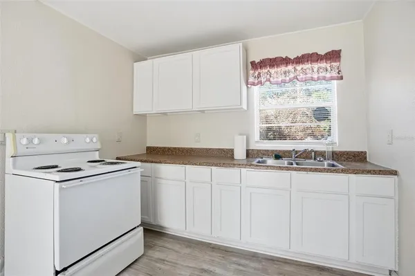 a kitchen with granite countertop white cabinets and white appliances