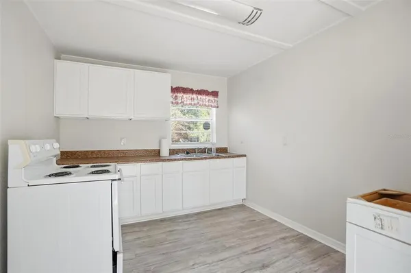 a kitchen with granite countertop a stove a sink and a microwave