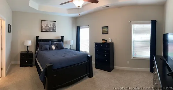 a bedroom with a bed and a flat tv screen on dresser