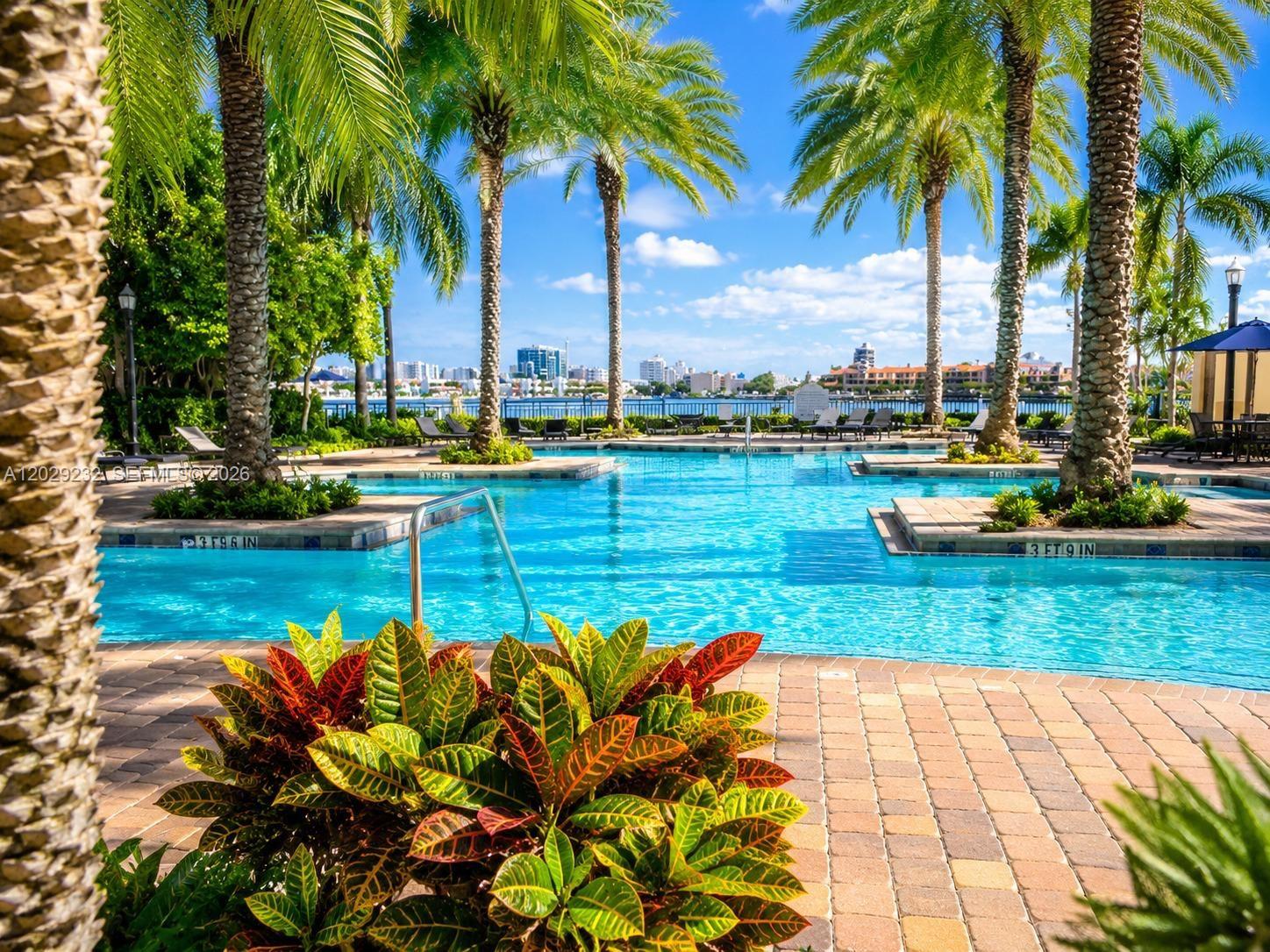 17100 North Bay Road, Unit 1605 Sunny Isles Beach, FL 33160 - Photo 40 of 52 a view of a swimming pool with a table and chairs