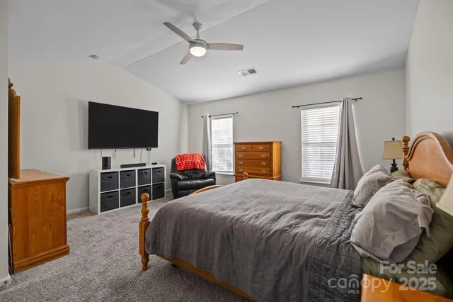 a bed room with a bed television and a flat tv screen