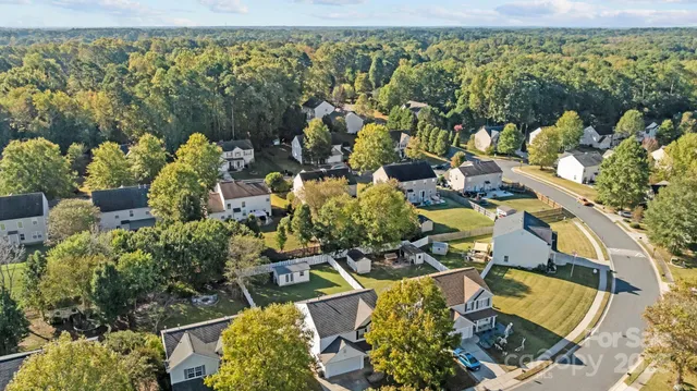 an aerial view of a house with a yard and lake view
