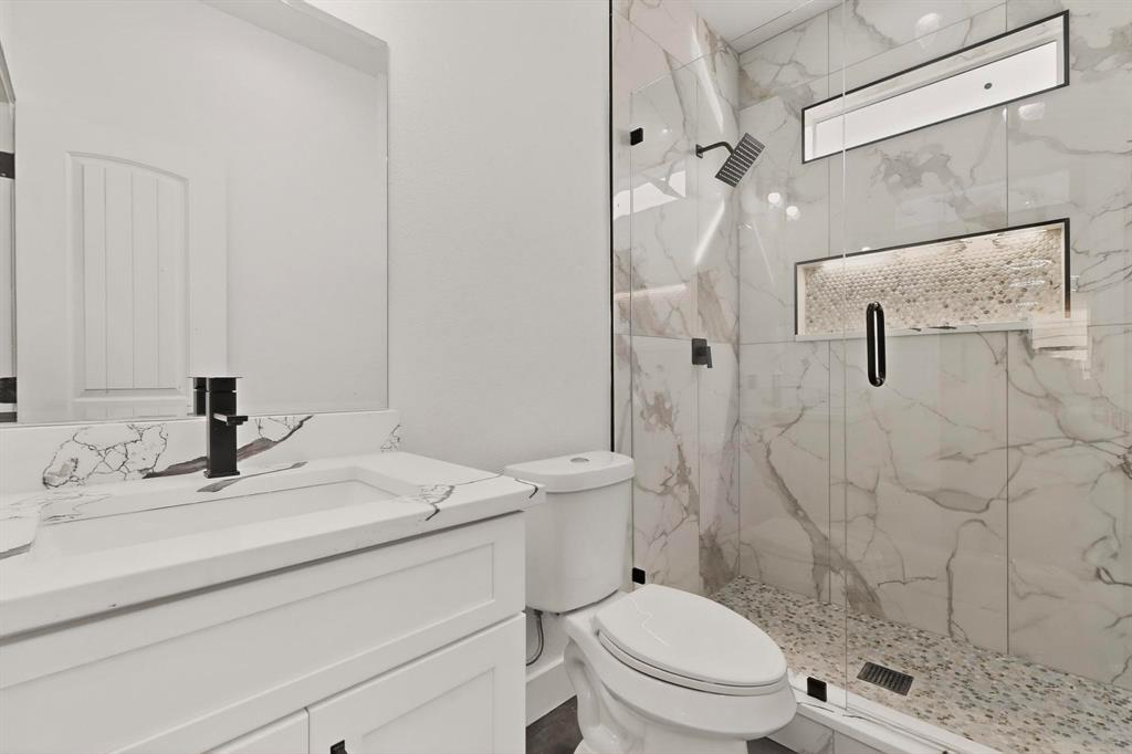 6039 Plum Dale Road Dallas, TX 75241 - Photo 11 of 38 a bathroom with a sink toilet vanity and shower