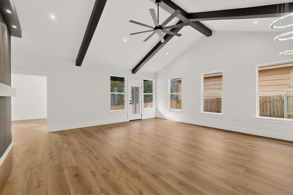 6039 Plum Dale Road Dallas, TX 75241 - Photo 7 of 38 a view of an empty room with wooden floor and a window