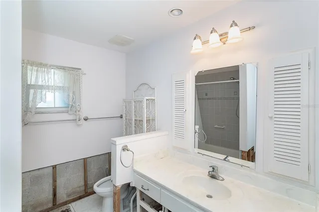 a bathroom with a sink a toilet and mirror