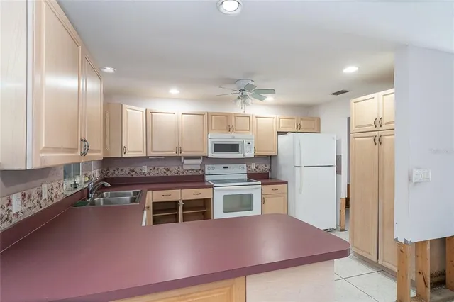 a kitchen with refrigerator and chairs