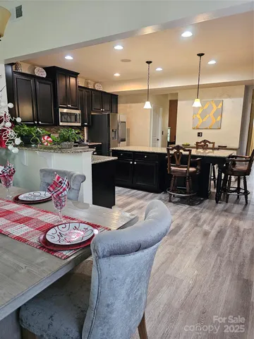 a large kitchen that has a lot of cabinets table and chairs
