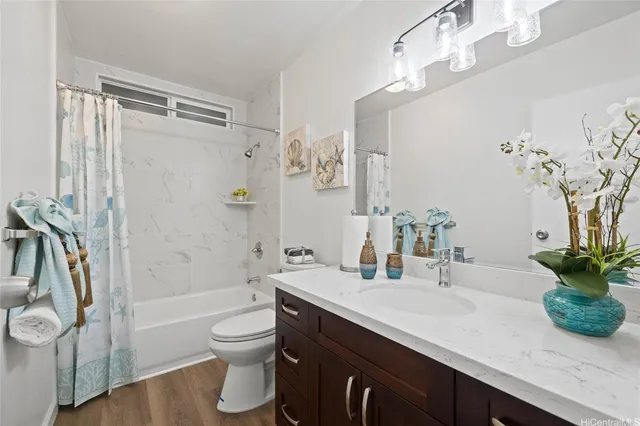 a bathroom with a granite countertop sink a toilet and shower