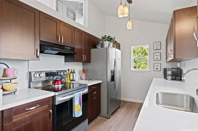 a kitchen with stainless steel appliances granite countertop a refrigerator sink and stove