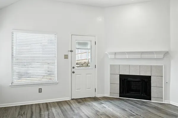 an empty room with windows and fireplace