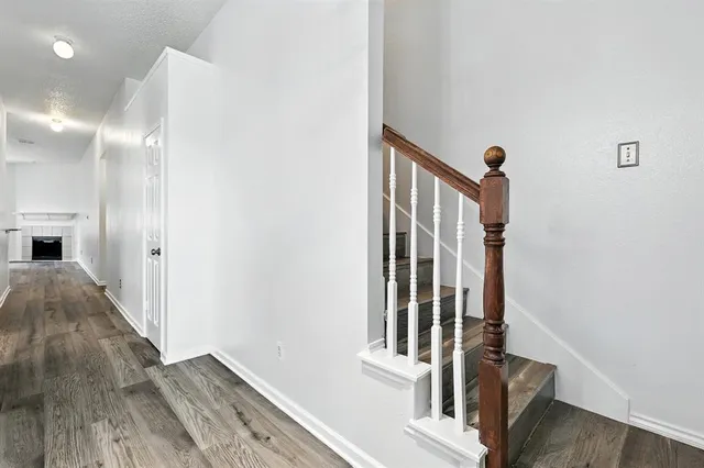 a view of a hallway with wooden floor and staircase