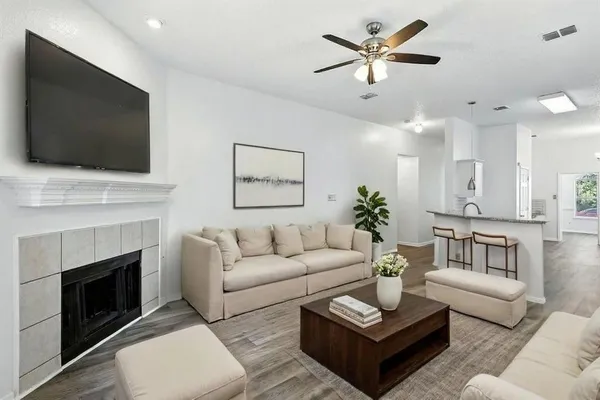 a living room with furniture a flat screen tv and a fireplace