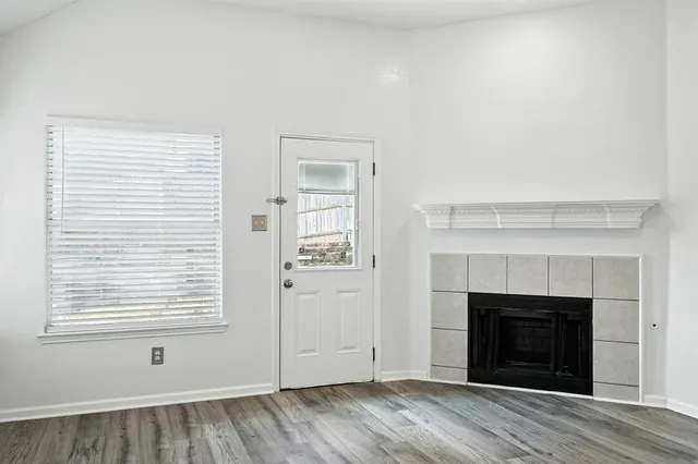 an empty room with windows and fireplace