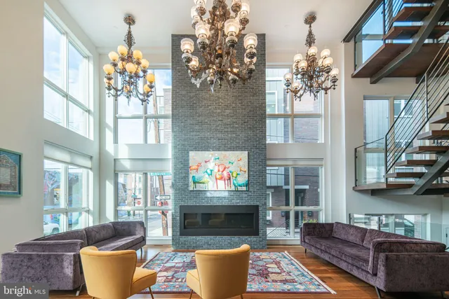 a living room with furniture a fireplace and a chandelier