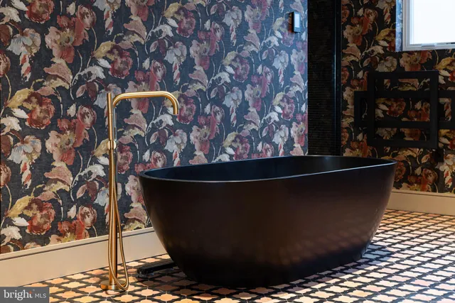 a living room with furniture a flat screen tv and a floor to ceiling window