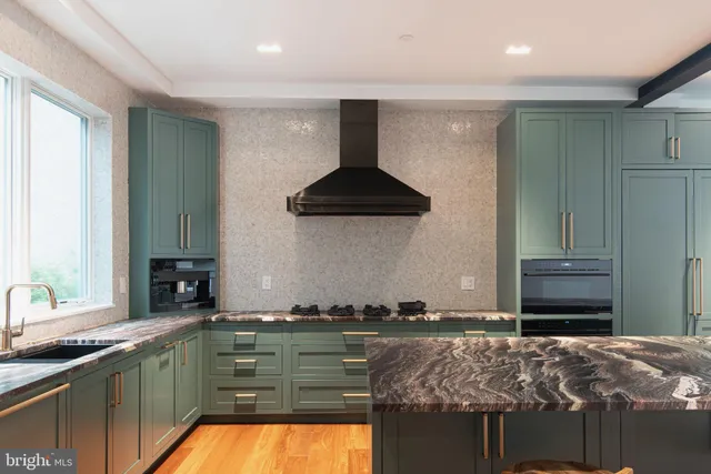 a kitchen with stainless steel appliances granite countertop a sink and a stove