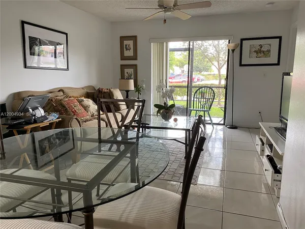 a living room with furniture a floor to ceiling window and a flat screen tv