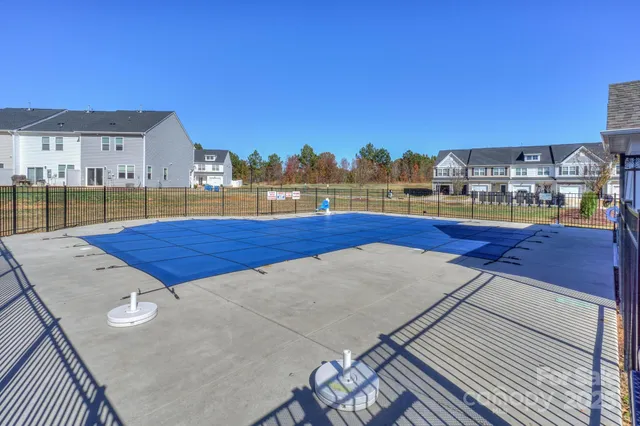 a view of swimming pool with outdoor seating and buildings in the background