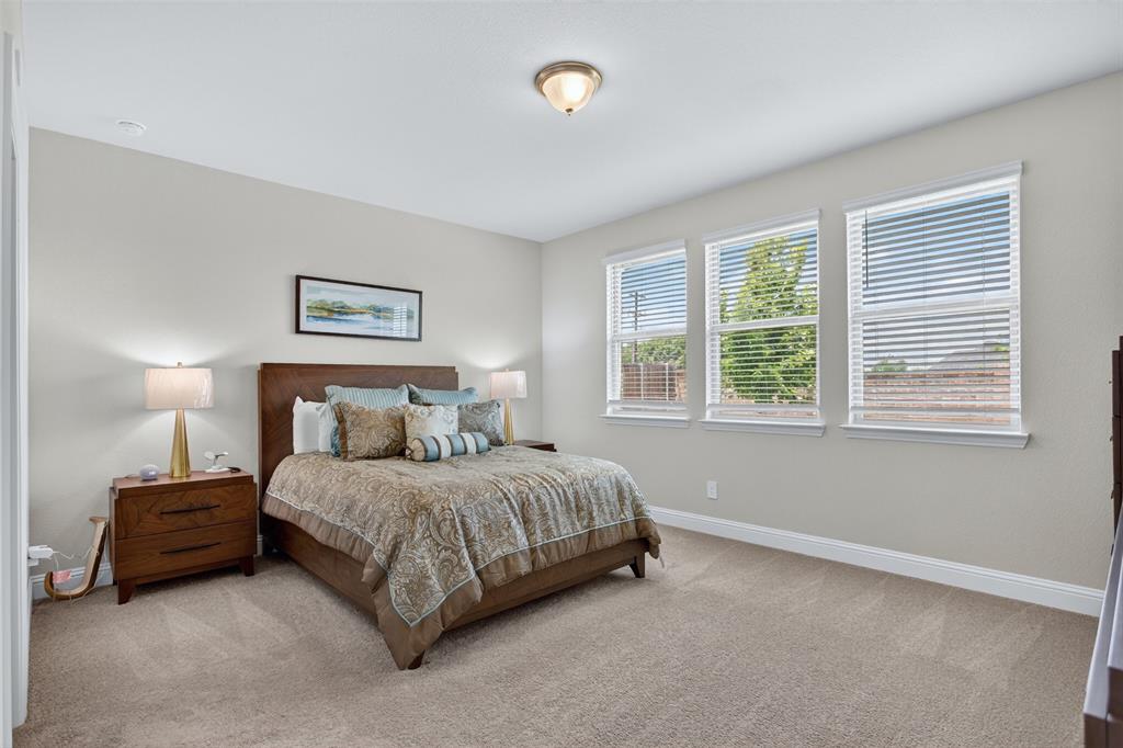 1002 Coppersmith Way Forney, TX 75126 - Photo 6 of 39 a bedroom with a bed lamp and a window