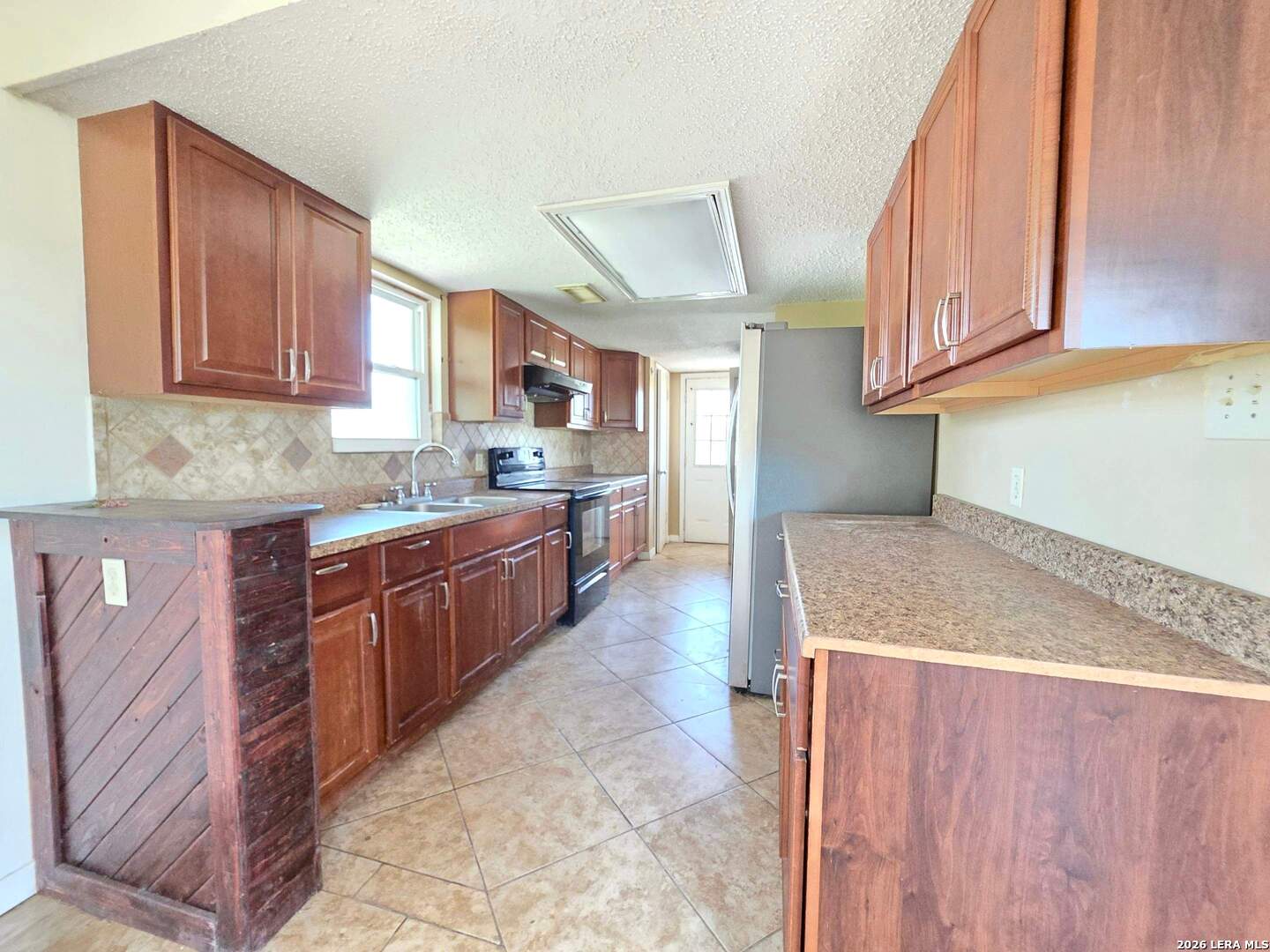 15506 Wheeler Road, Unit 4 Atascosa, TX 78002 - Photo 6 of 23 a kitchen with stainless steel appliances granite countertop a sink stove and cabinets