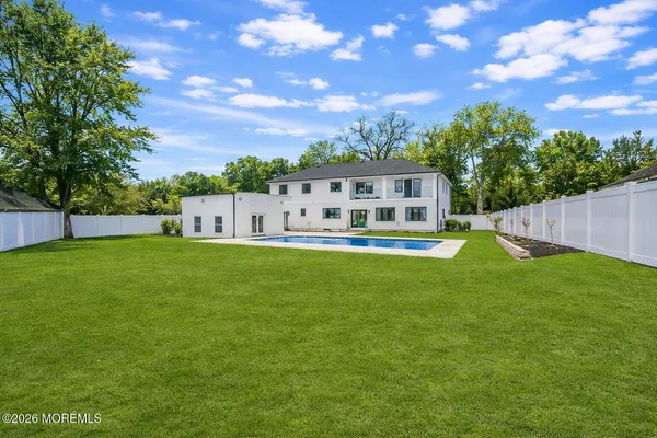 an aerial view of a house with a garden and lake view