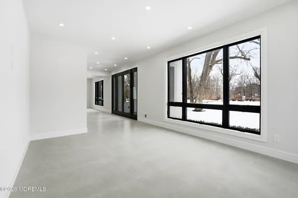 an empty room with kitchen and natural light