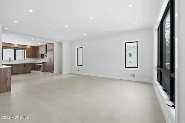a large white kitchen with large windows and sink