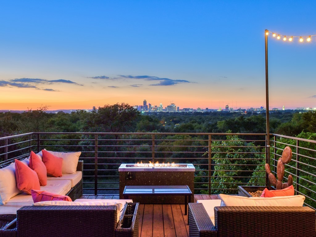 a view of a roof deck with couches and sky view