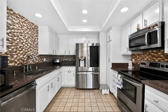a kitchen with stainless steel appliances a refrigerator sink and microwave